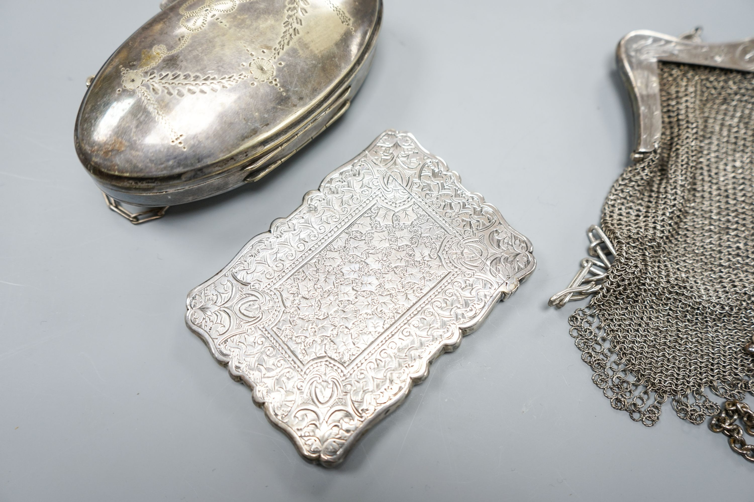 A late Victorian engraved silver card case, Birmingham, 1877, 10cm, a silver mesh evening purse and two other plated items.